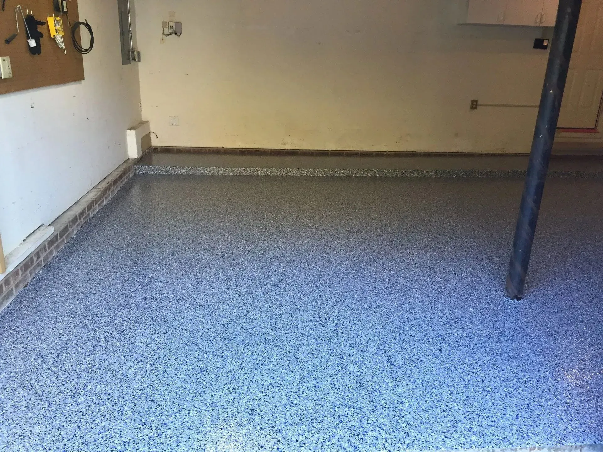 Garage with epoxy flooring in shades of blue and gray.