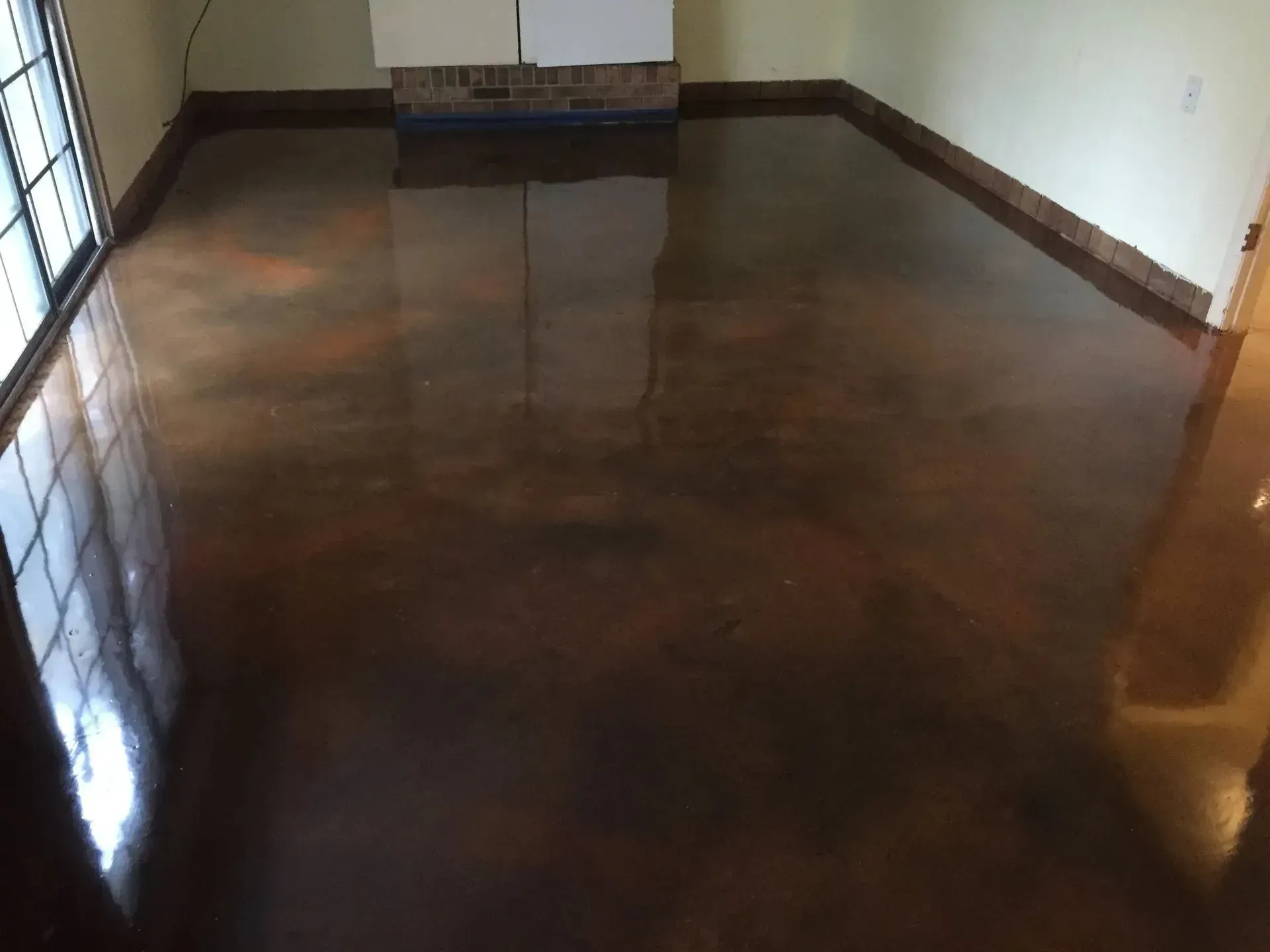 Metallic copper-colored epoxy flooring in a room, reflecting light with a glossy finish.