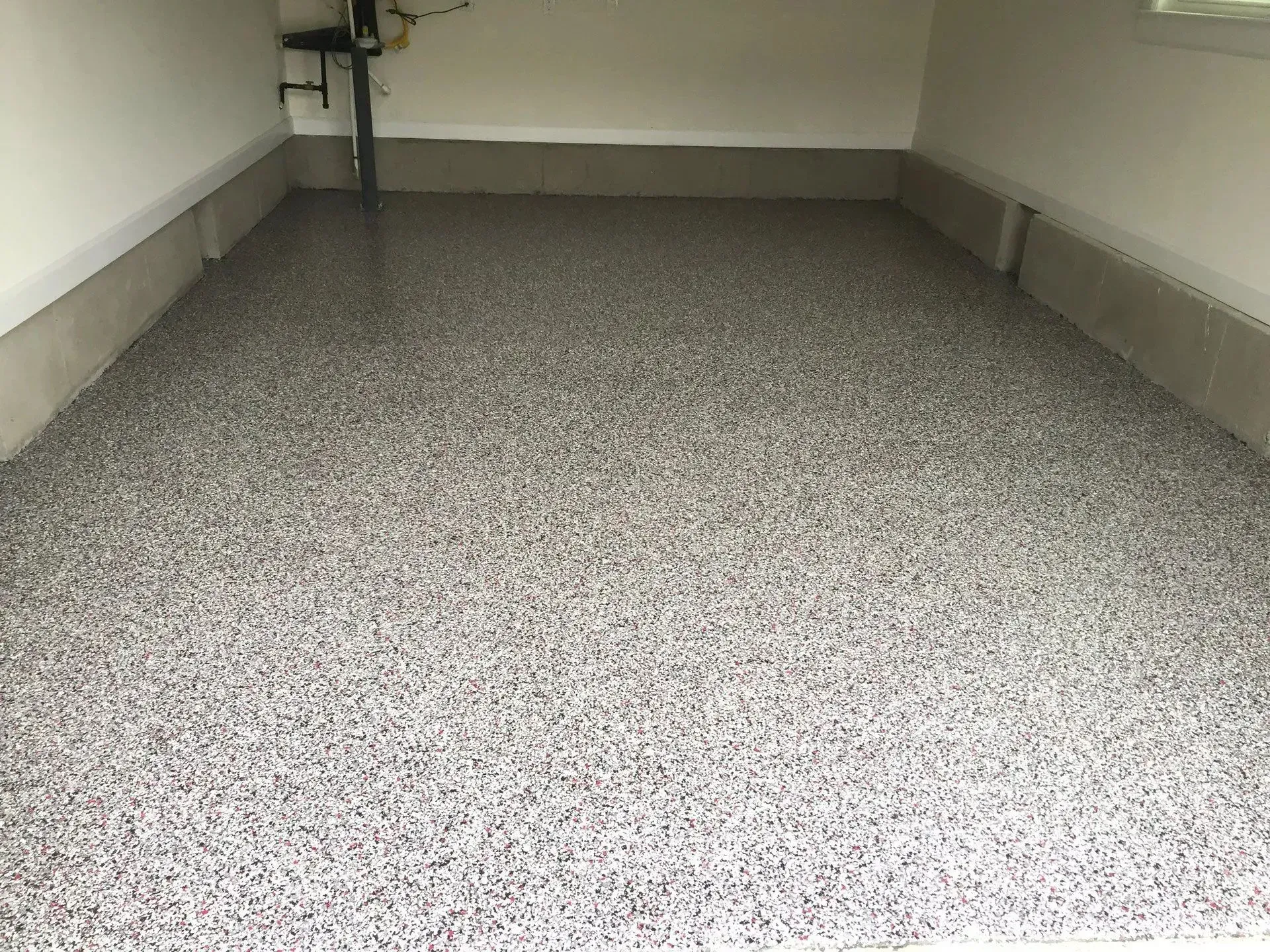 Garage floor with speckled epoxy coating.
