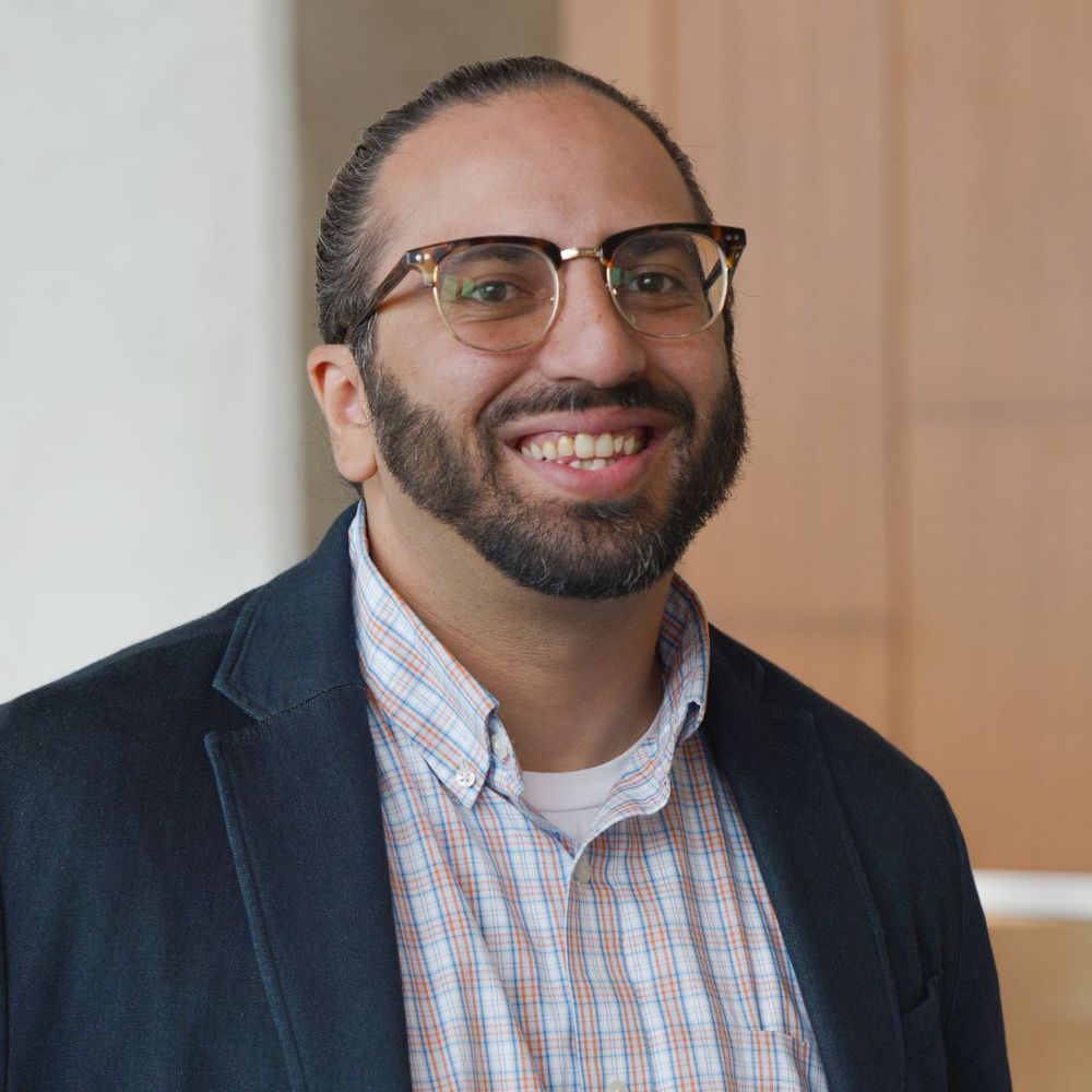 A man with a beard and glasses is smiling for the camera.