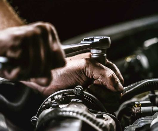 Auto mechanic working on car engine in mechanics garage