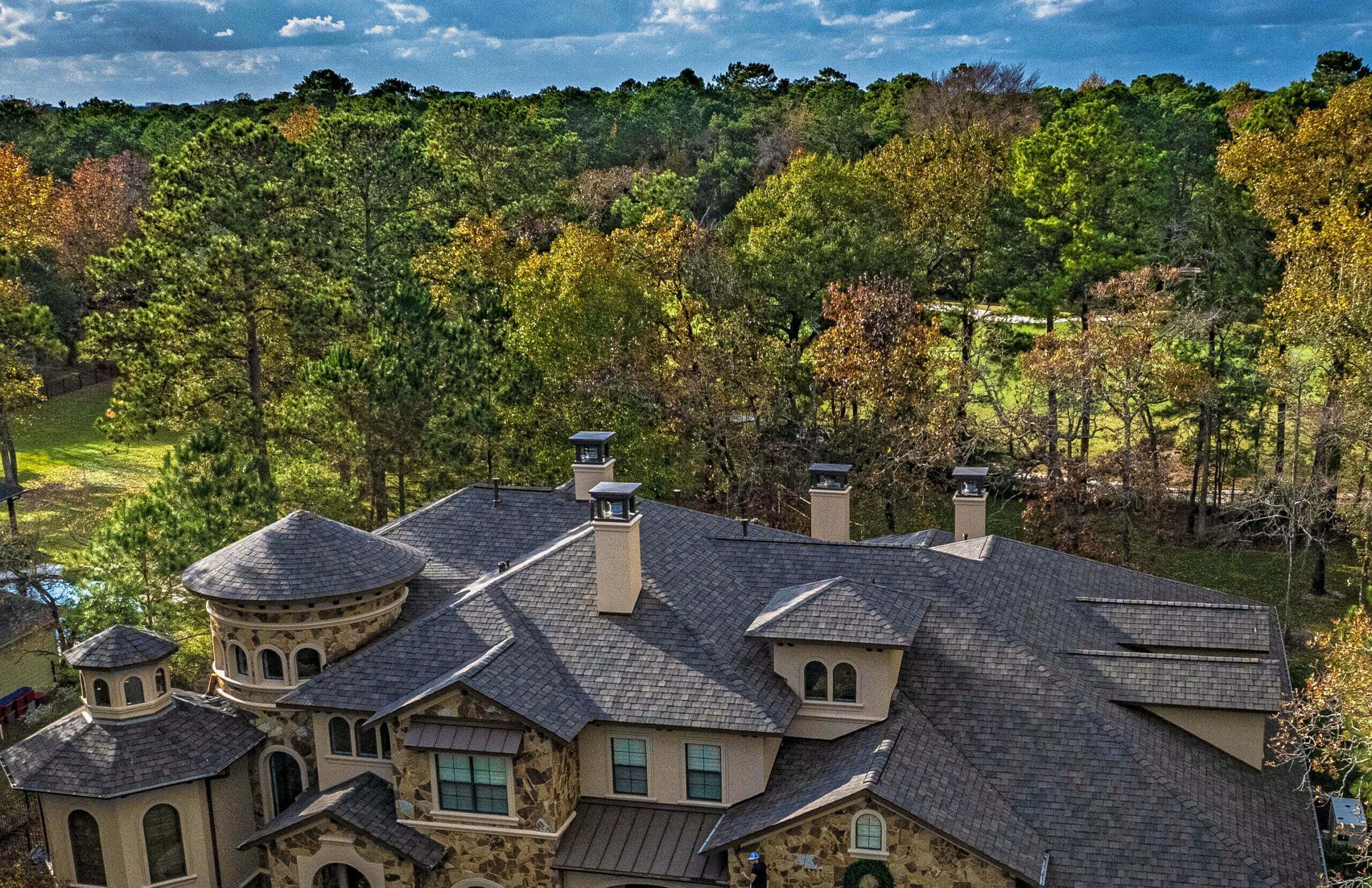 An aerial view of a large house surrounded by trees