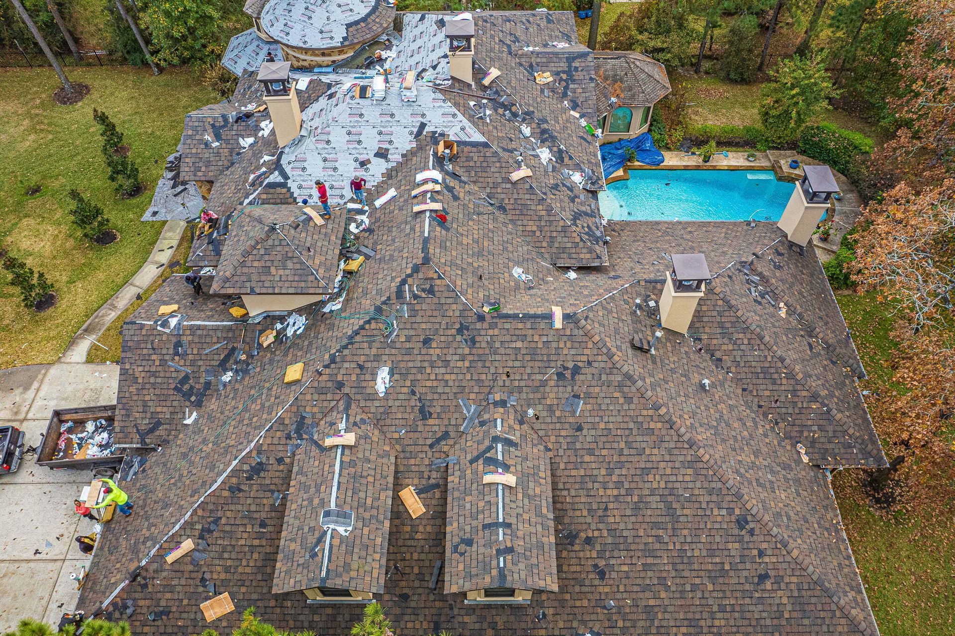 An aerial view of a large house with a pool in the backyard.