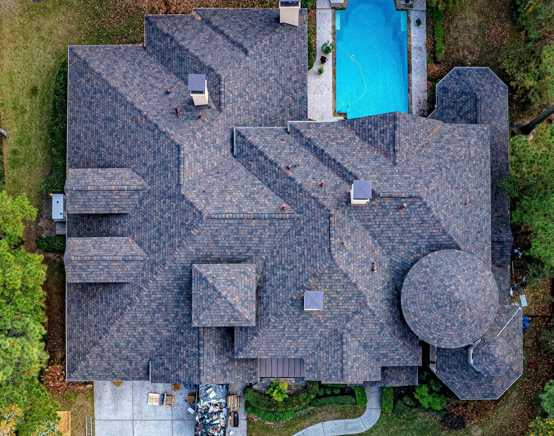 An aerial view of a large house with a pool in the backyard.