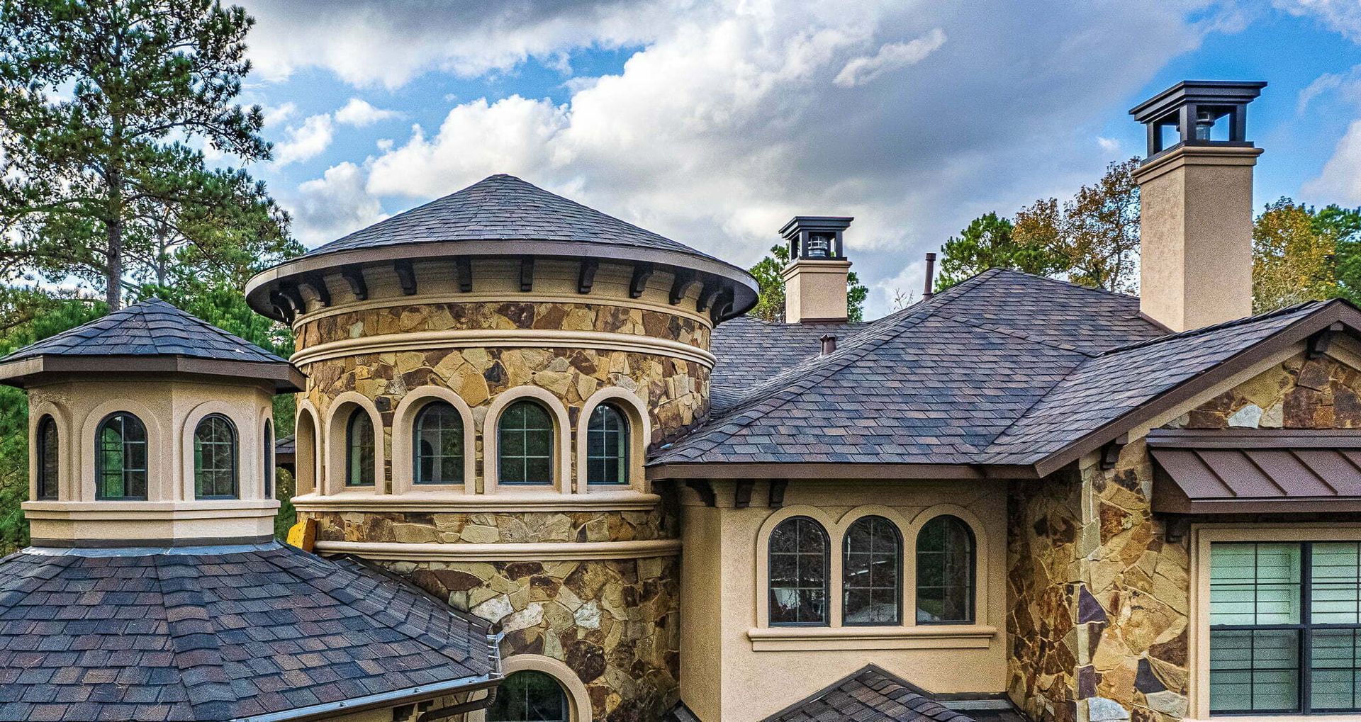 A large house with a lot of windows and chimneys on the roof.