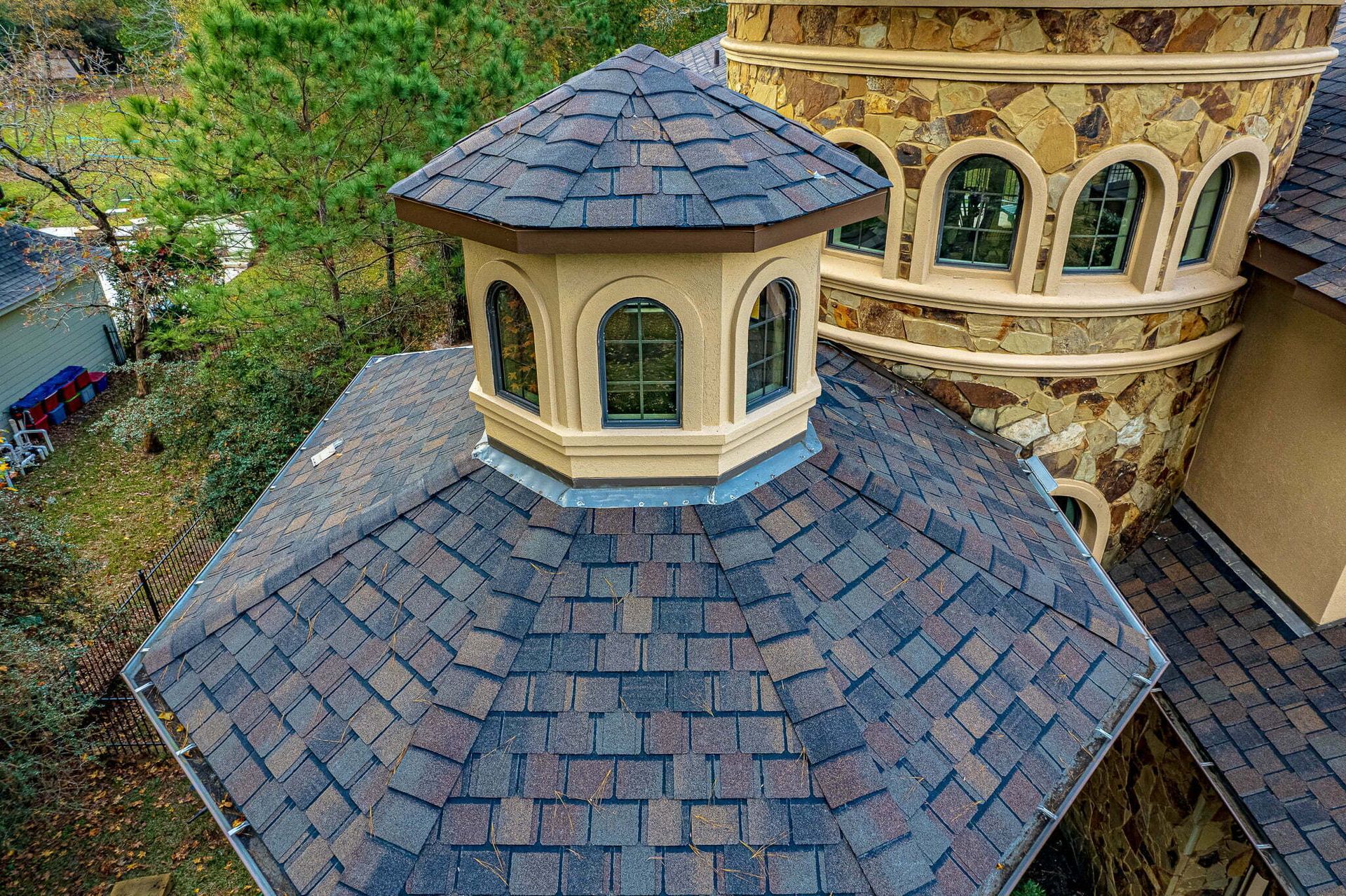 An aerial view of a large house with a roof that looks like a castle.