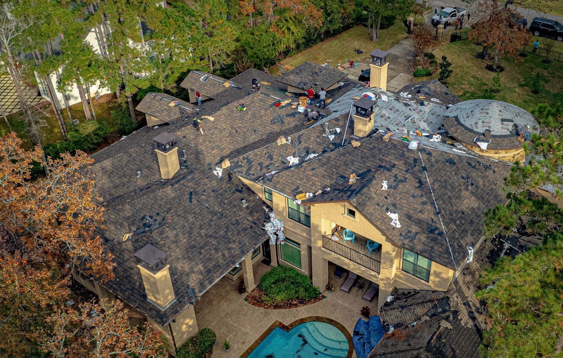 An aerial view of a large house with a pool in the backyard.