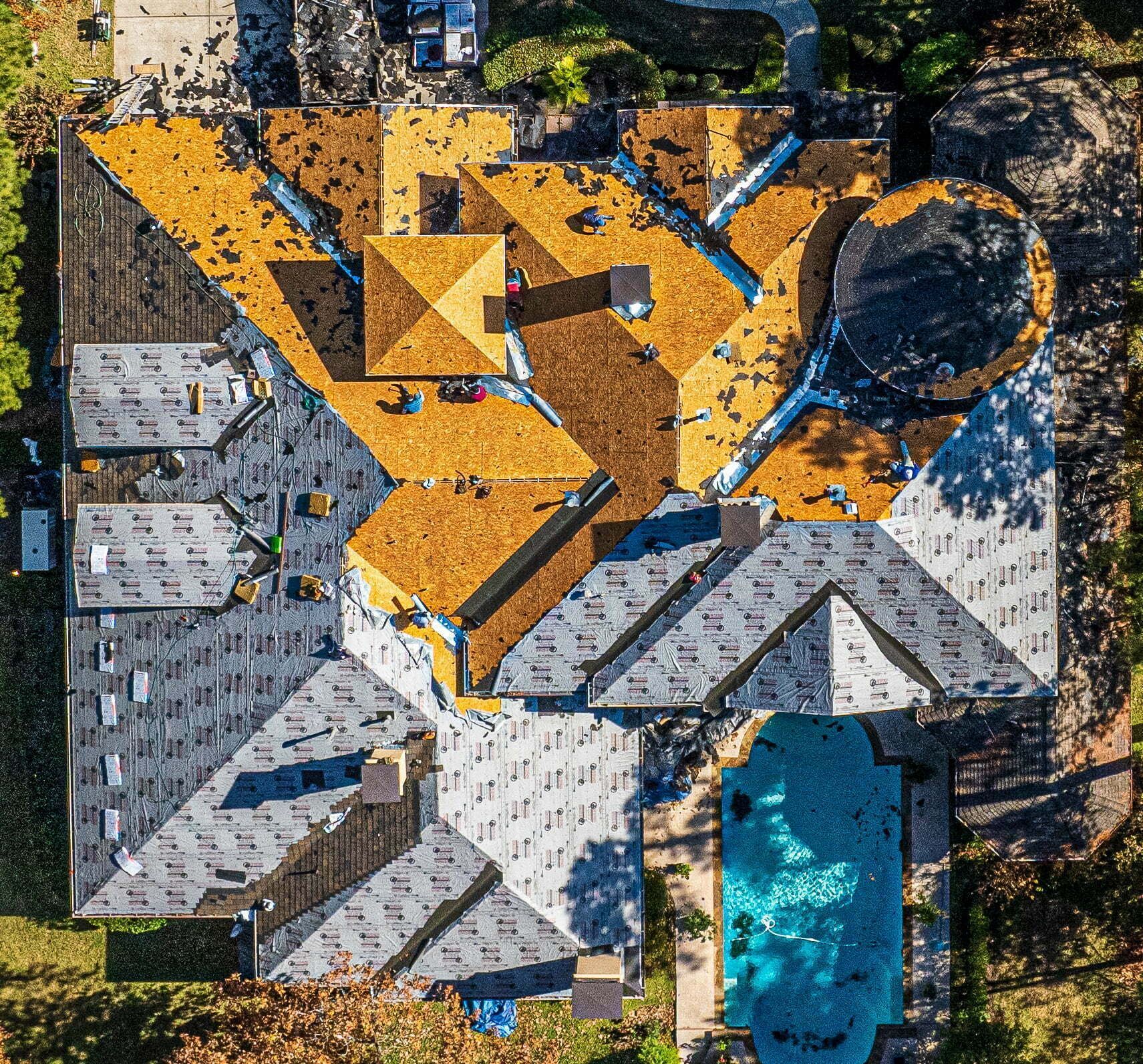 An aerial view of a house with a pool in the backyard