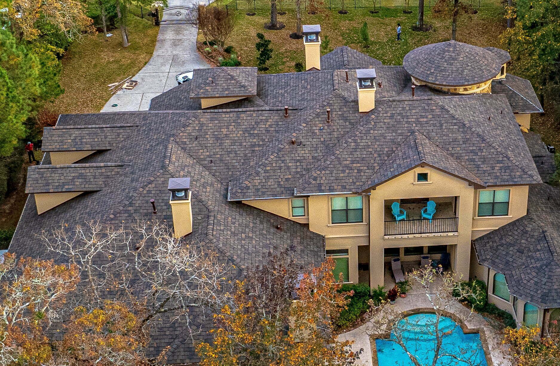 An aerial view of a large house with a pool in the backyard.