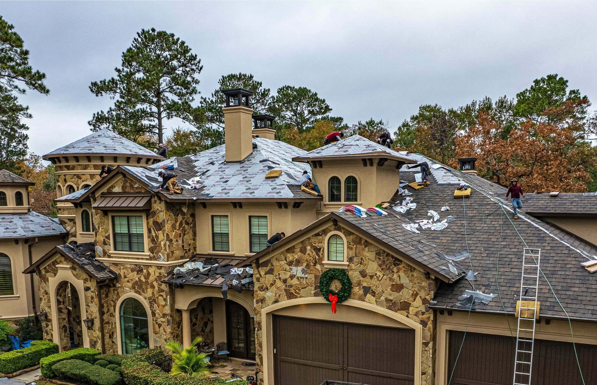 A large house with a wreath on the garage door is being remodeled.