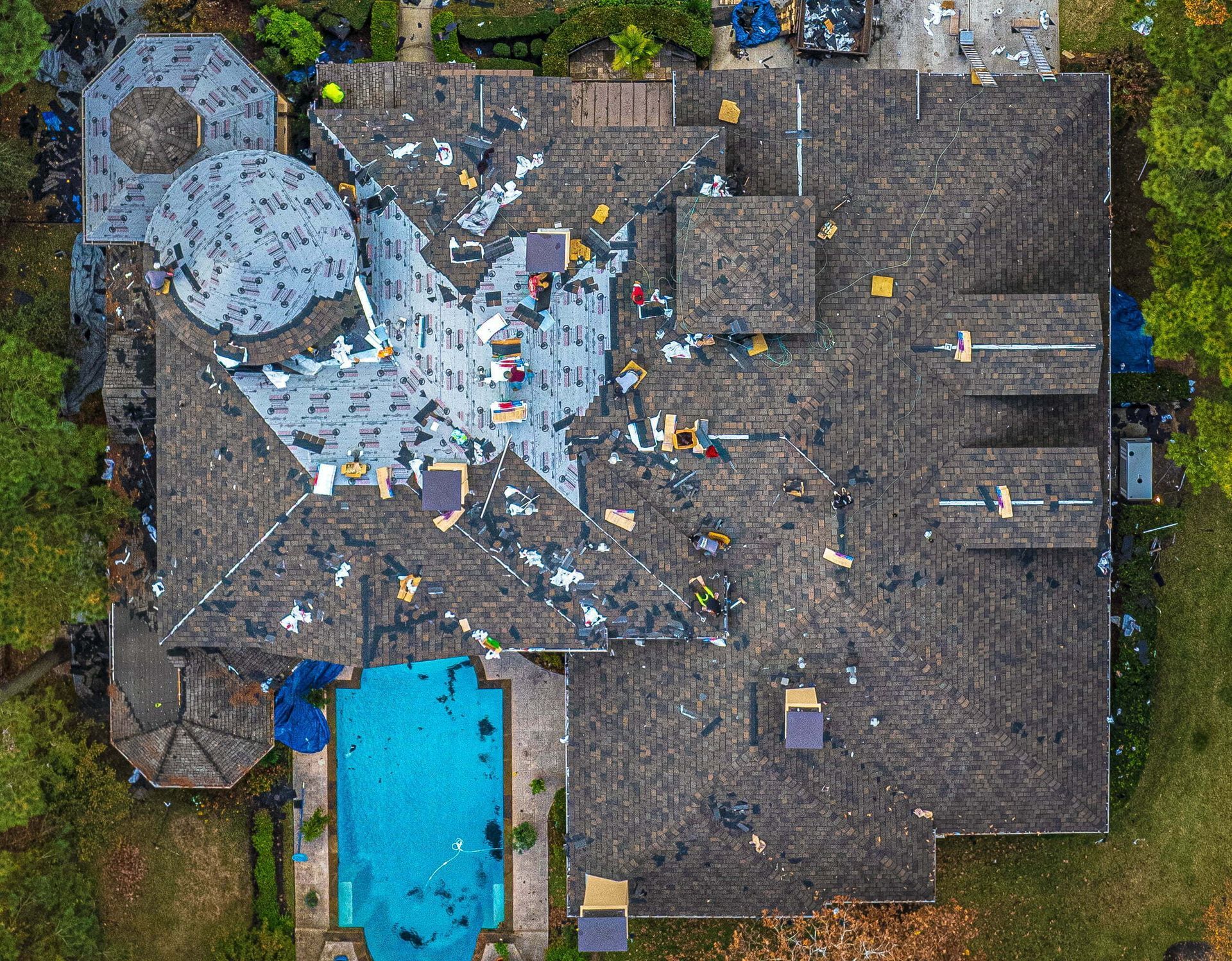 An aerial view of a large house with a pool in the backyard.