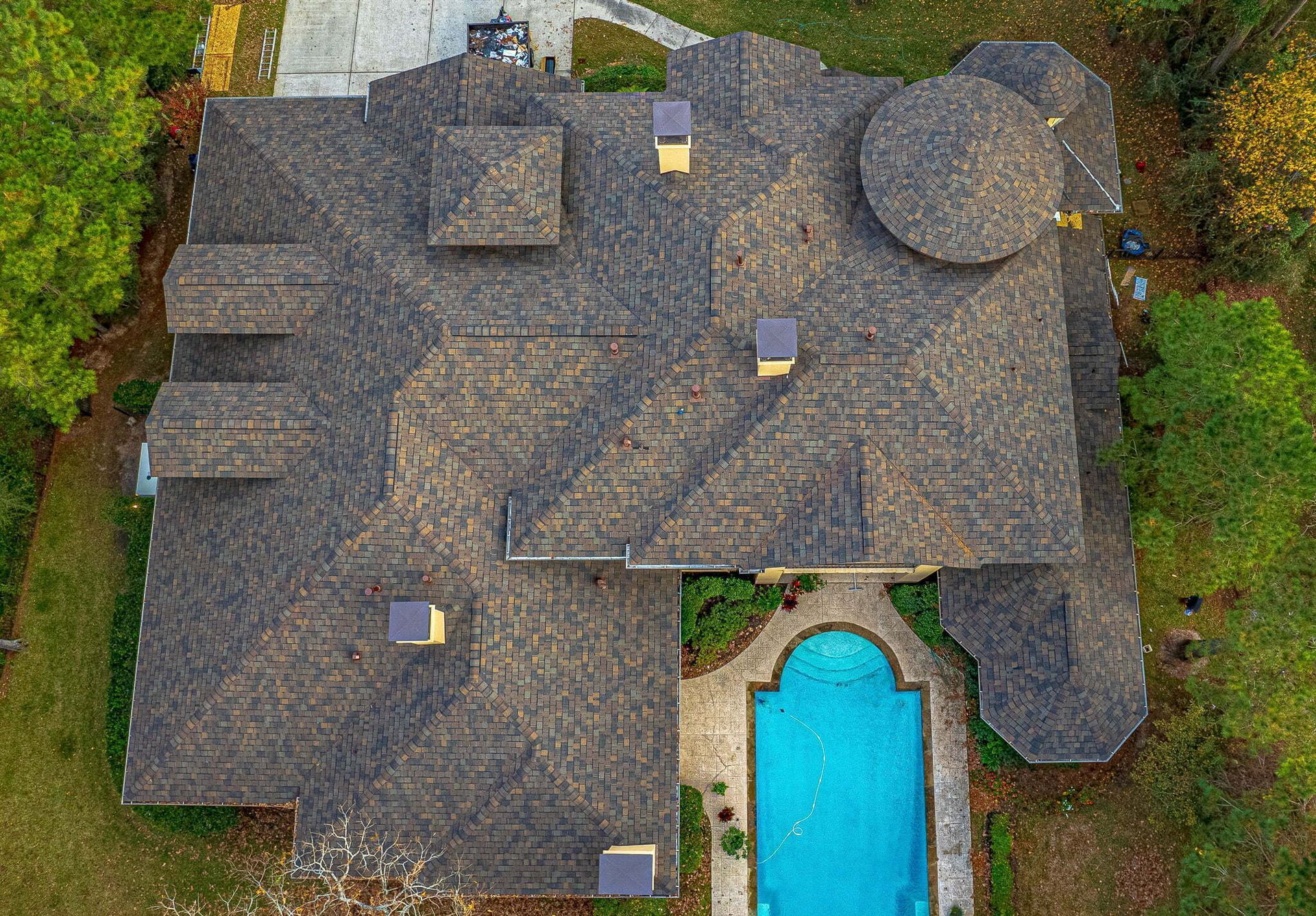 An aerial view of a large house with a pool in the backyard.