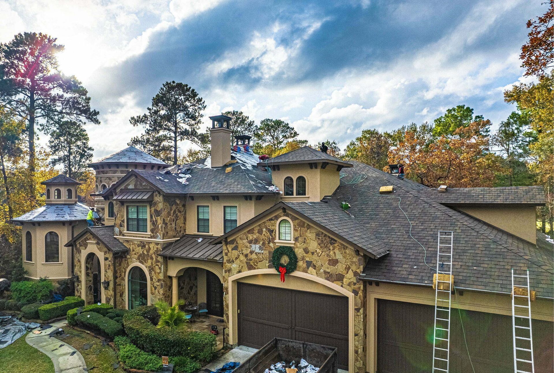 An aerial view of a large house with a wreath on the garage door.