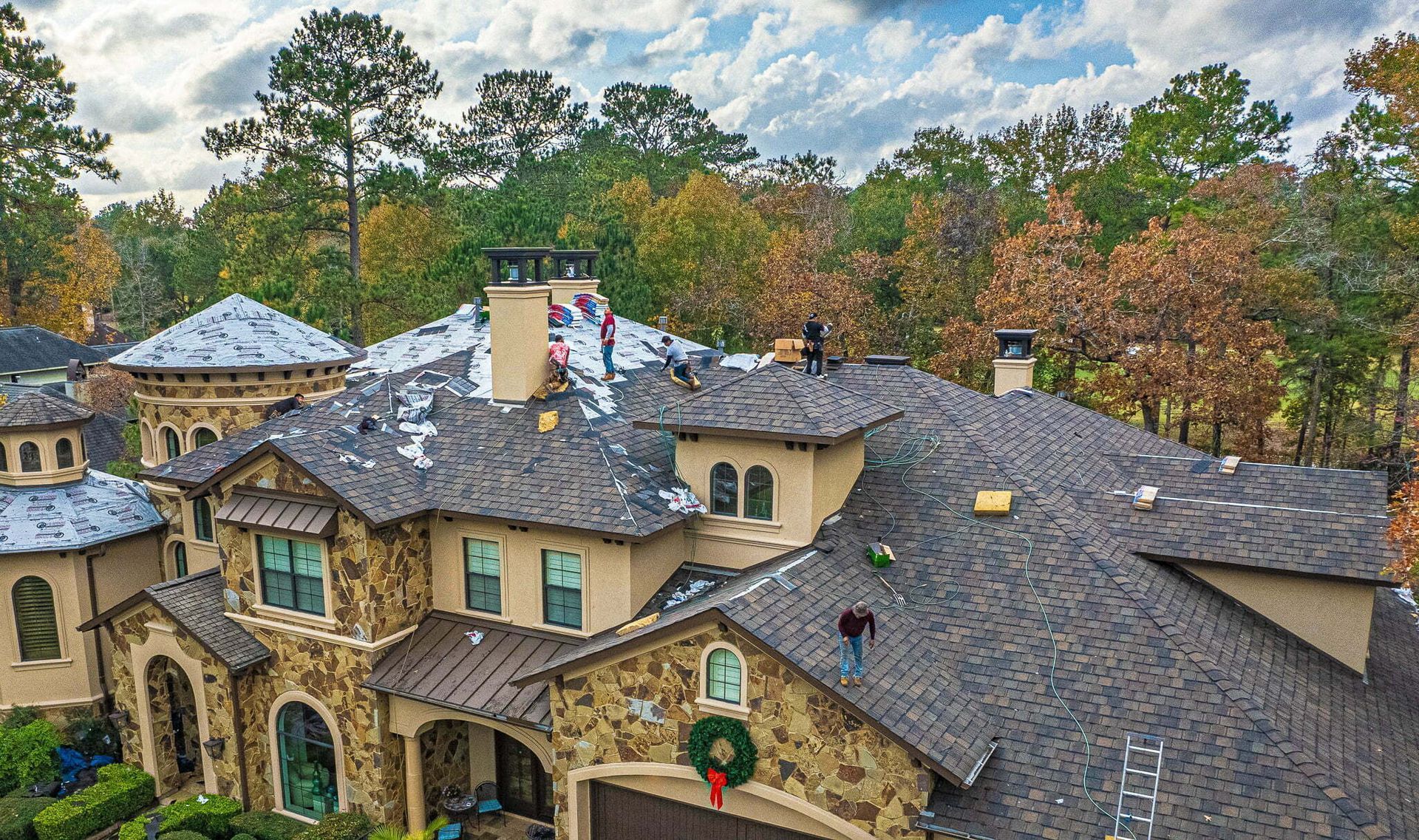 An aerial view of a large house with a roof being installed.
