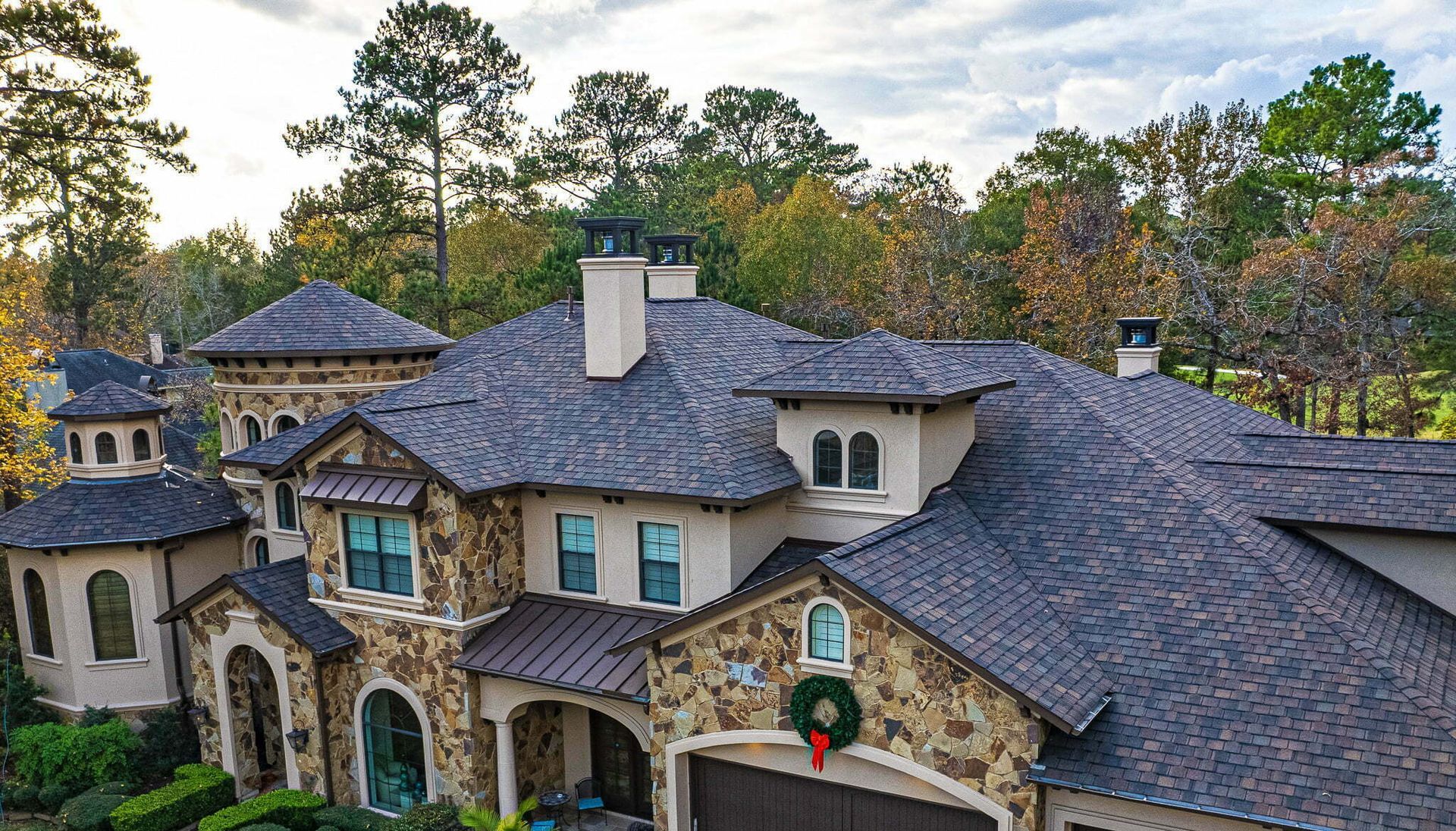 An aerial view of a large house with a wreath on the front of it.