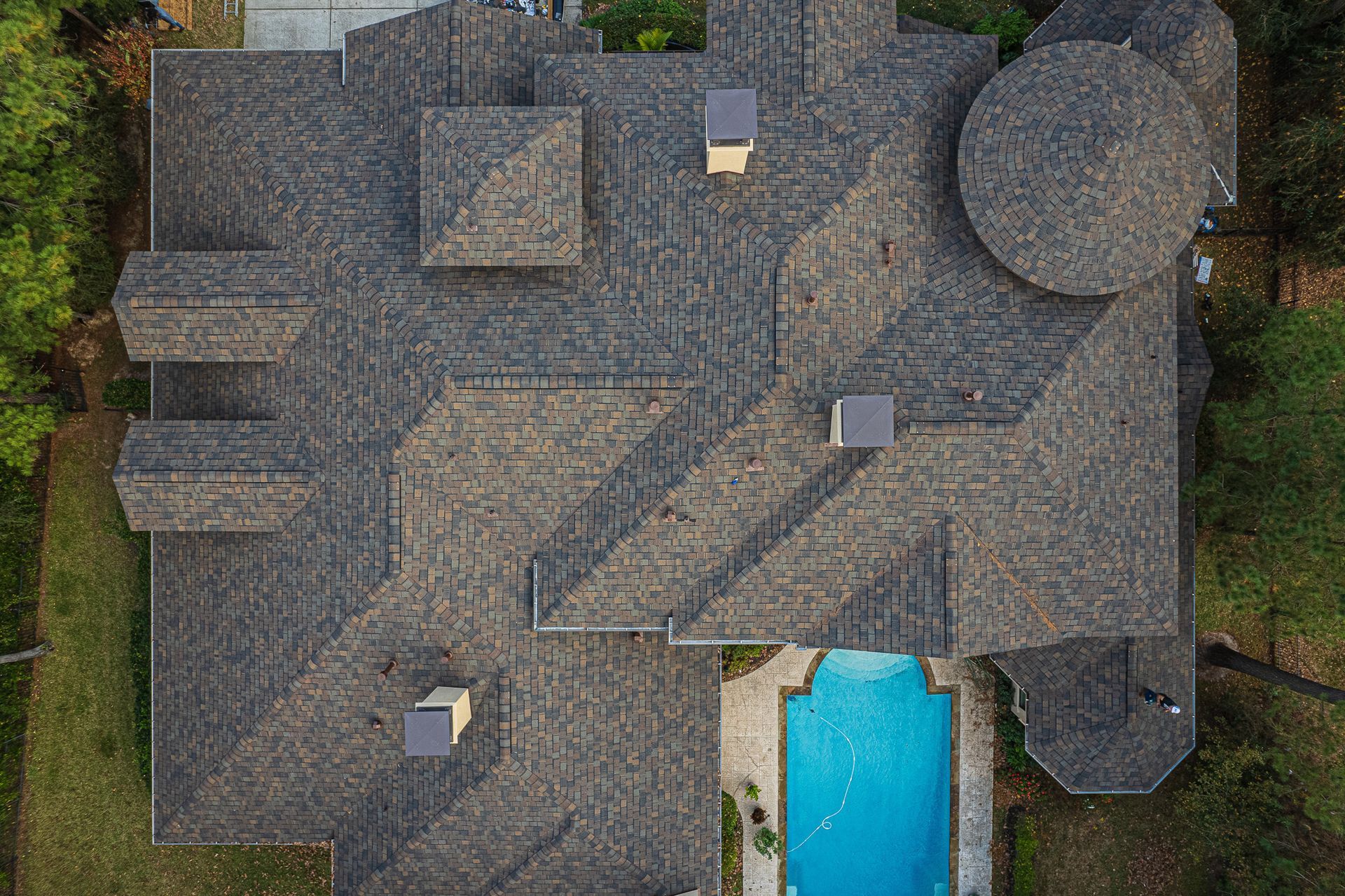 An aerial view of a large house with a pool in the backyard.