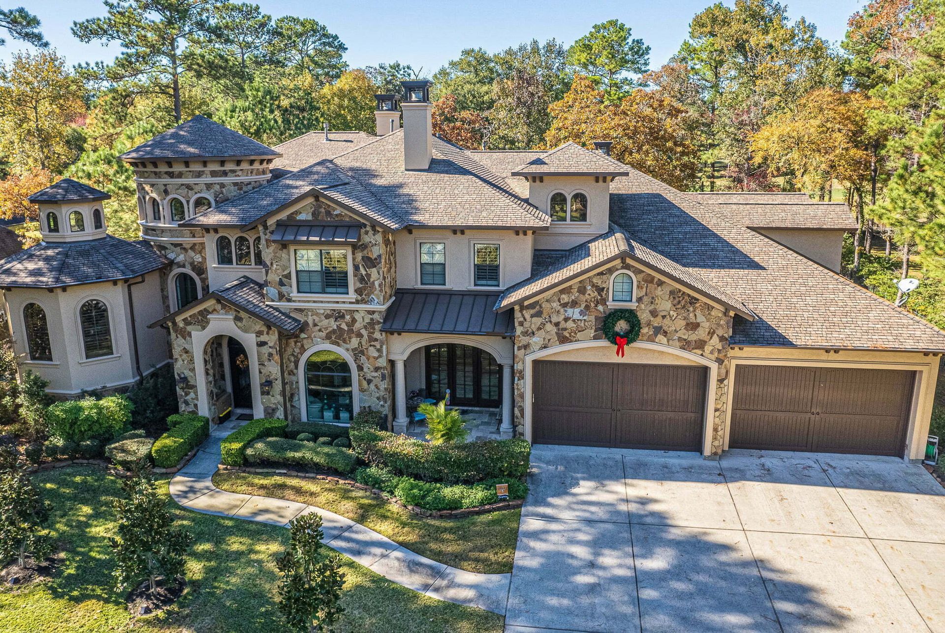 An aerial view of a large house with a wreath on the front.