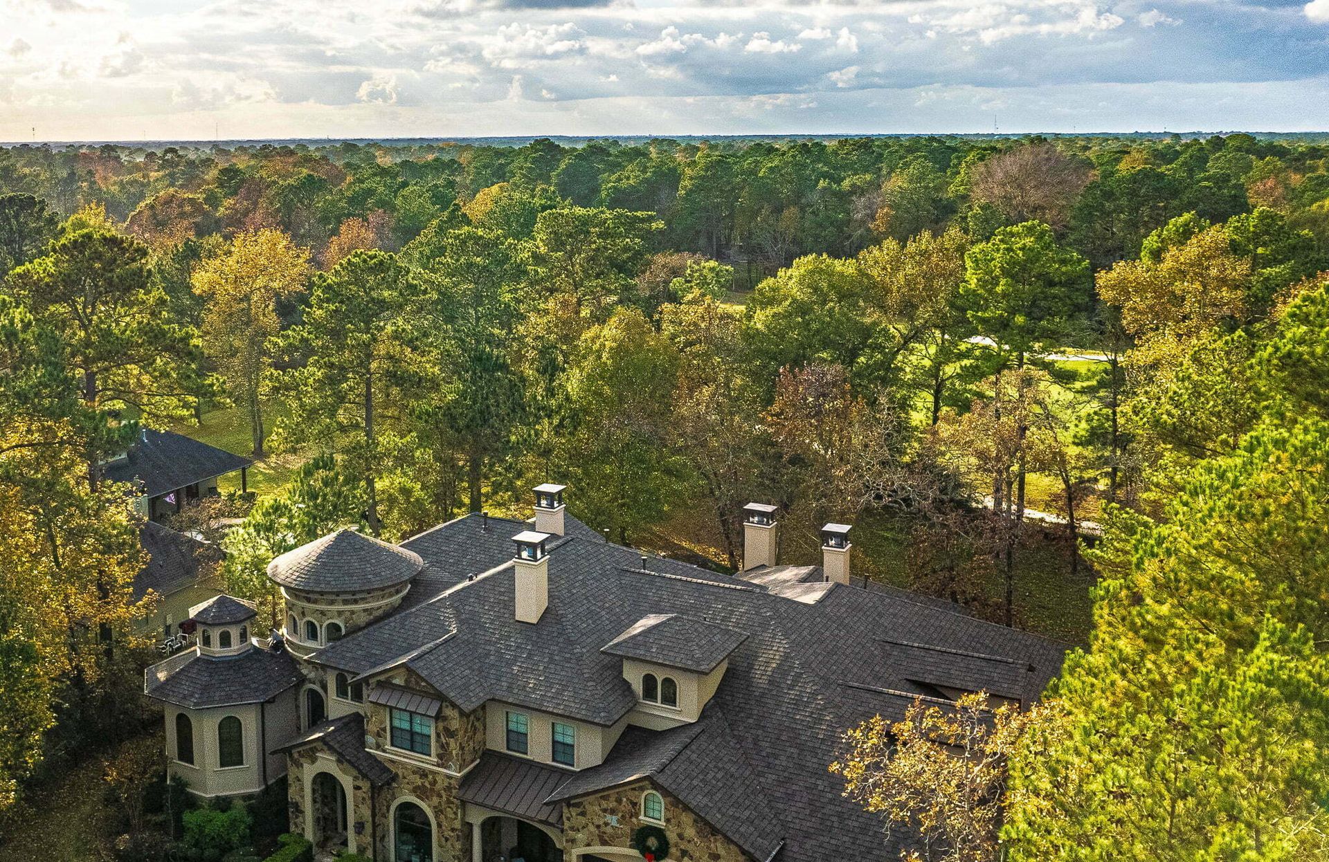 An aerial view of a large house surrounded by trees.