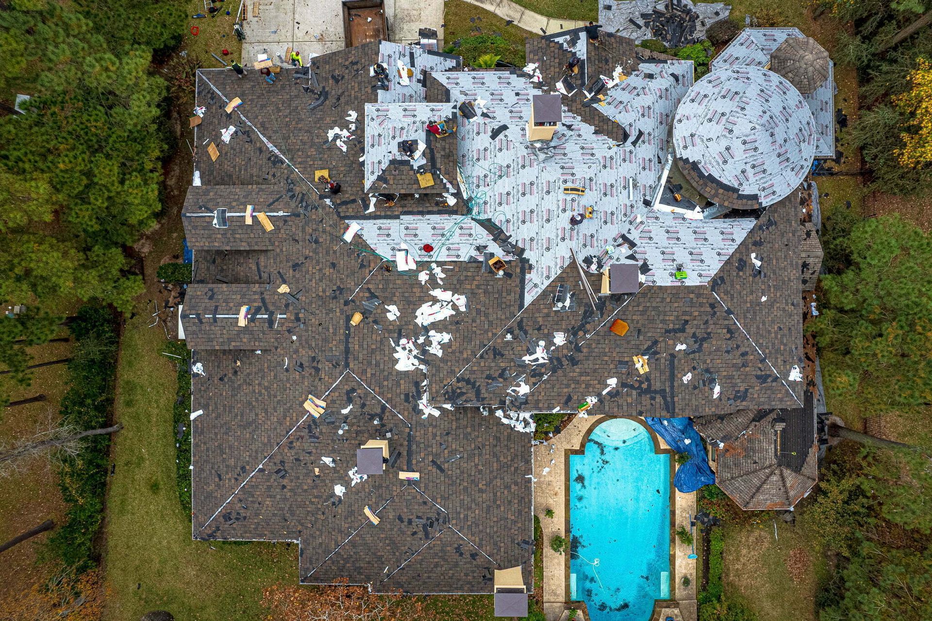 An aerial view of a house with a pool in the backyard.