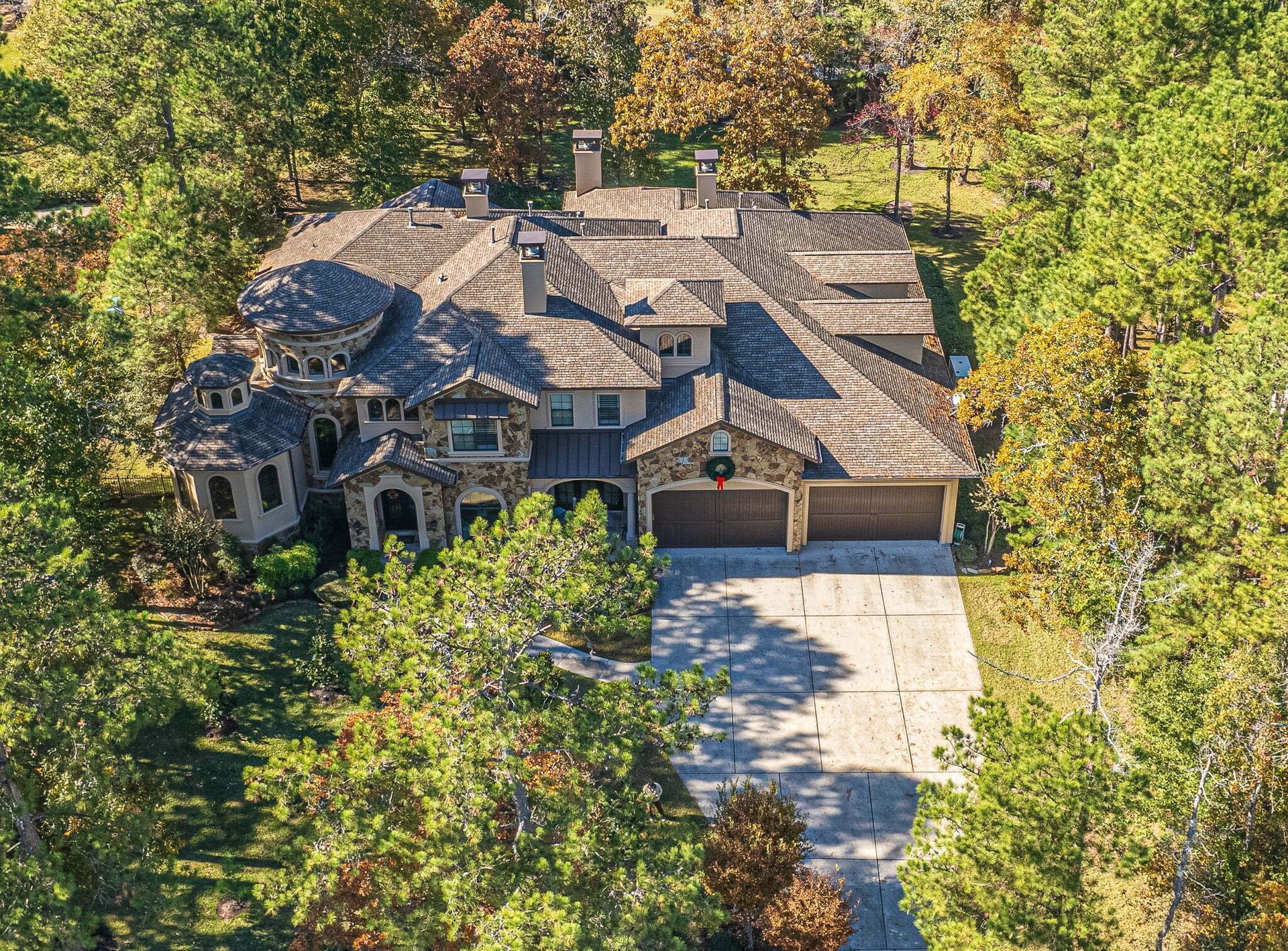 An aerial view of a large house surrounded by trees.