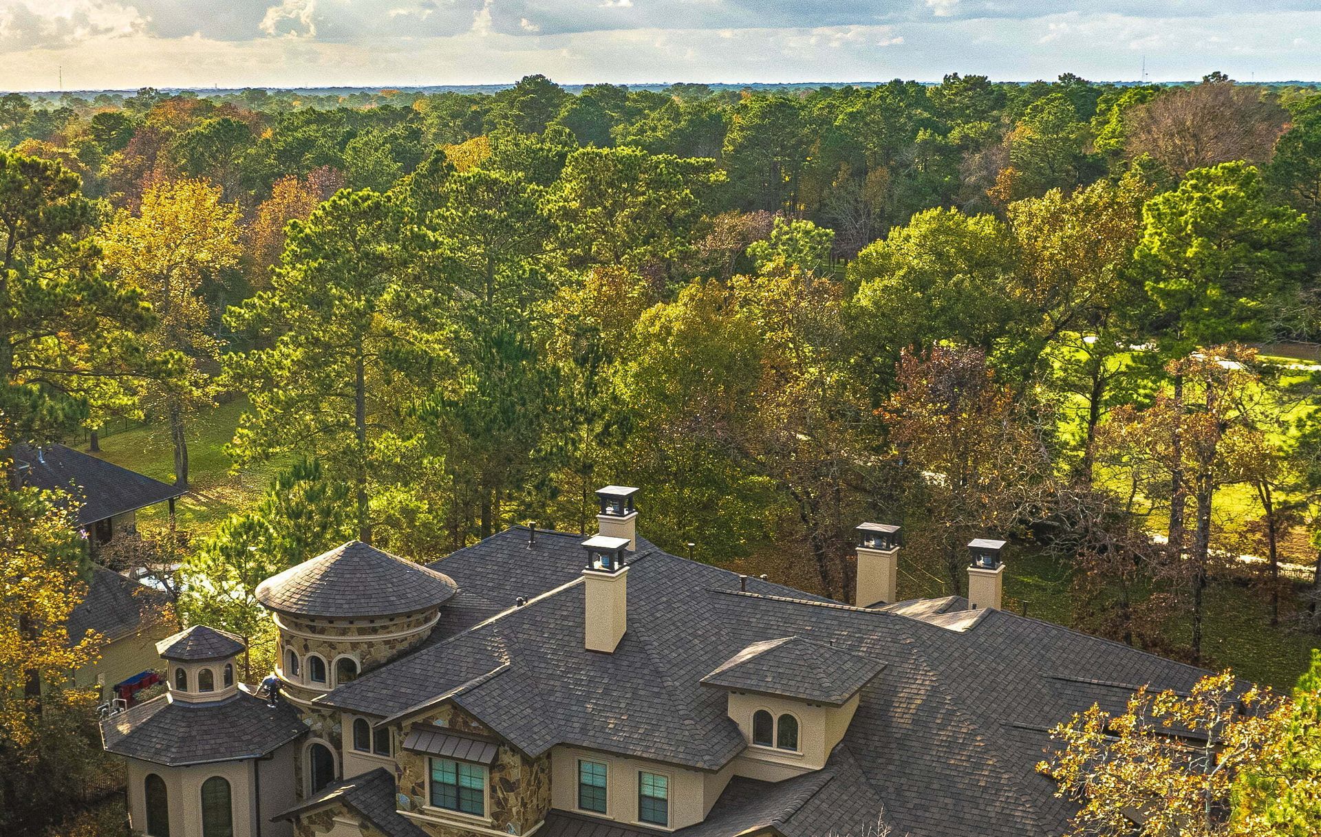 An aerial view of a large house surrounded by trees.
