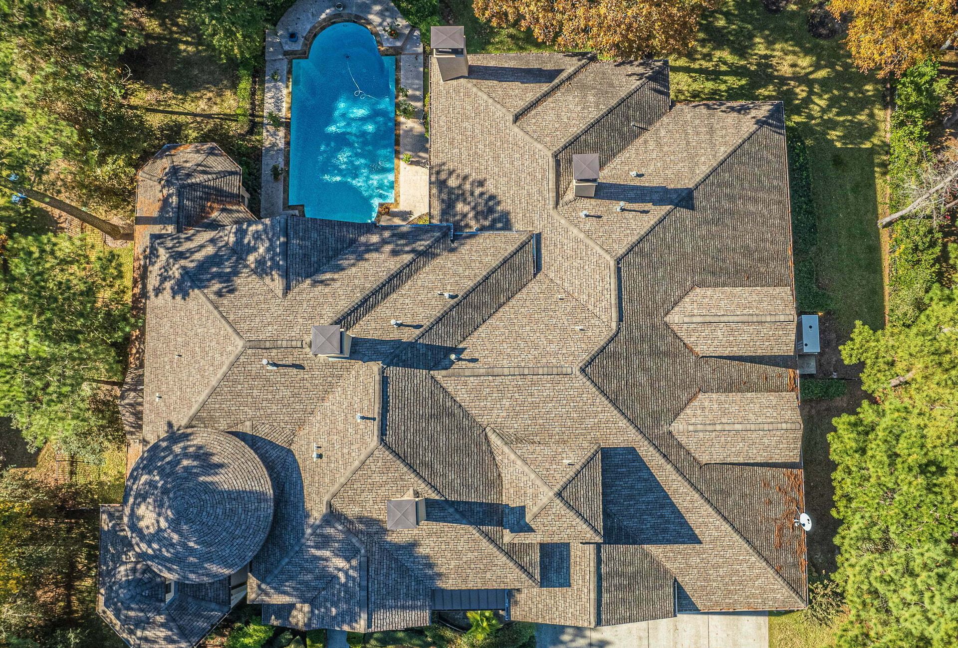 An aerial view of a house with a pool in the backyard.