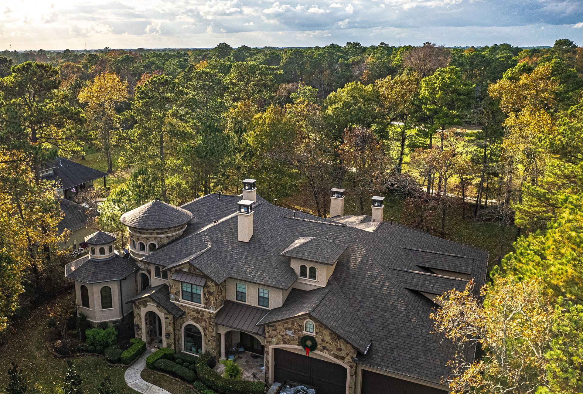 An aerial view of a large house surrounded by trees.