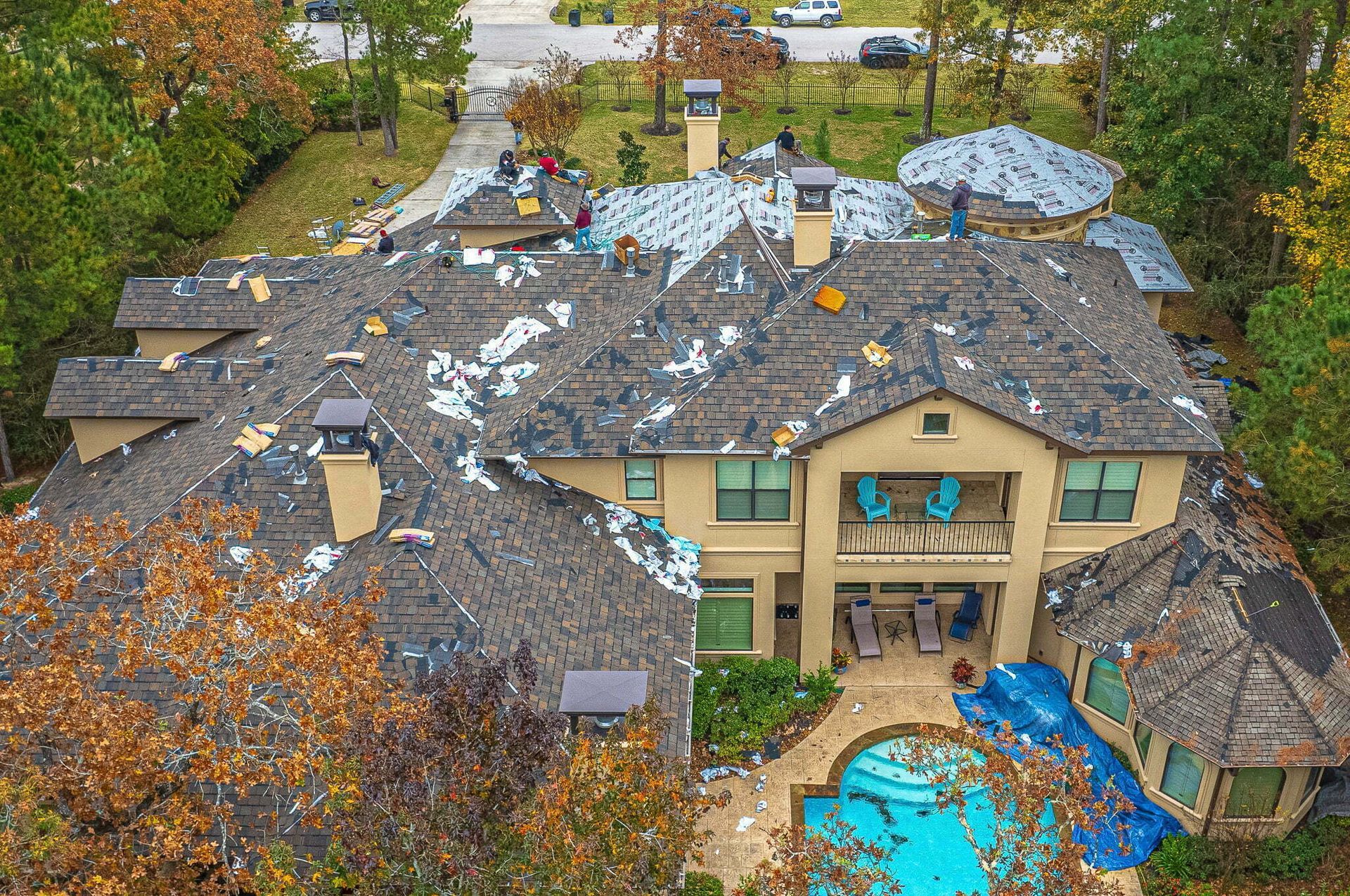An aerial view of a large house with a pool in the backyard.