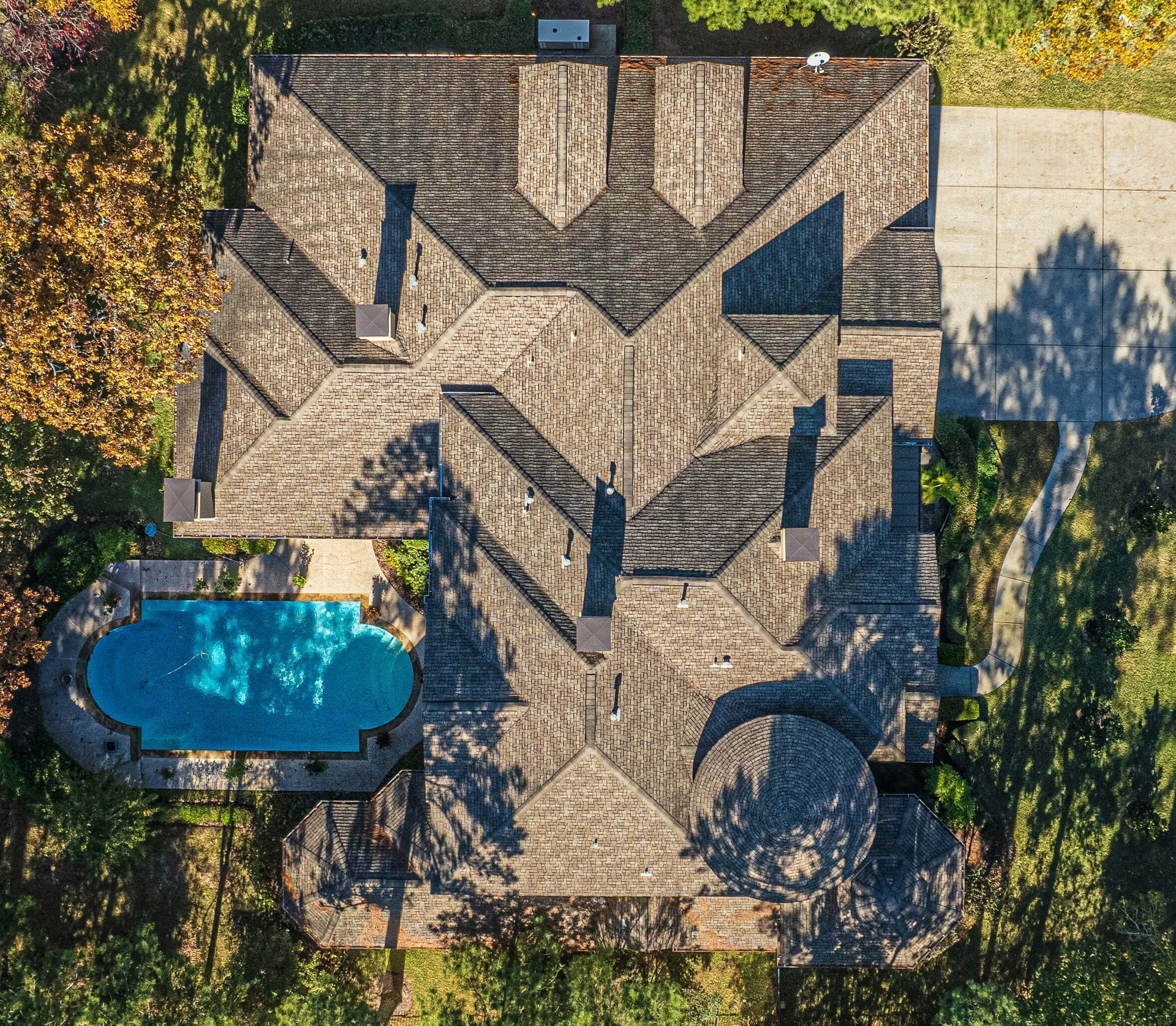 An aerial view of a house with a large pool