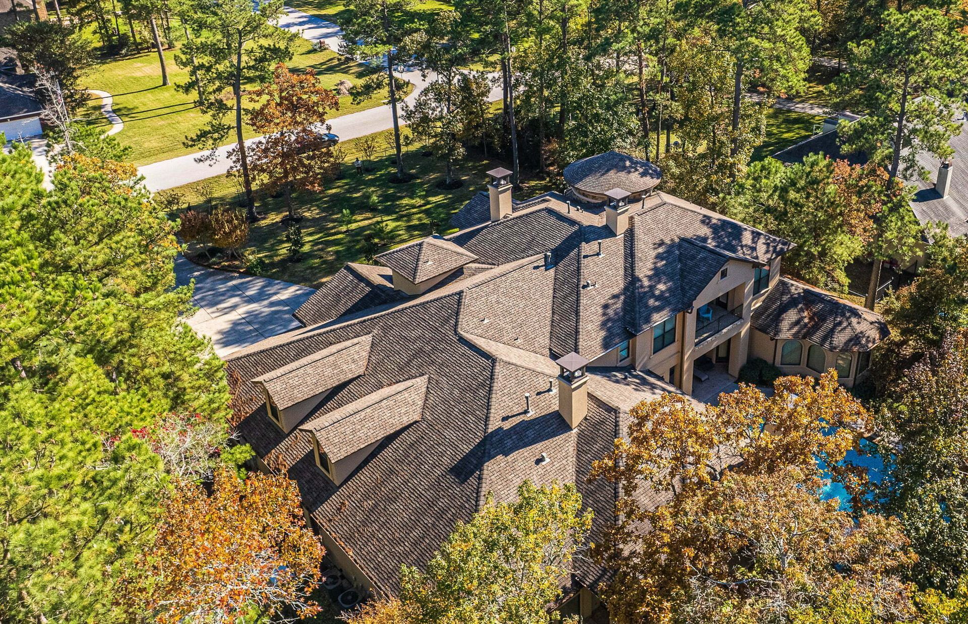 An aerial view of a large house surrounded by trees.
