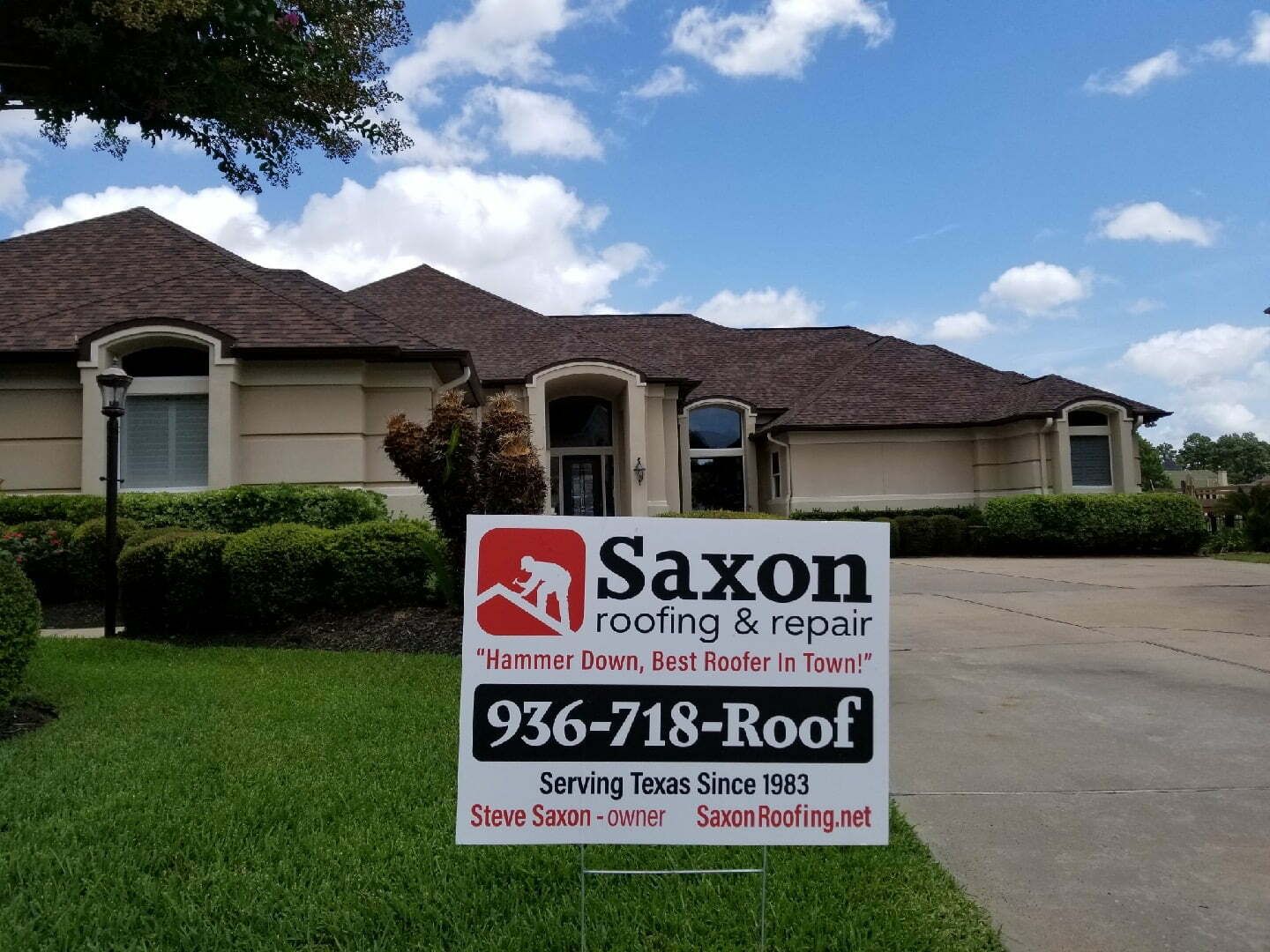 A saxon roofing and repair sign in front of a house