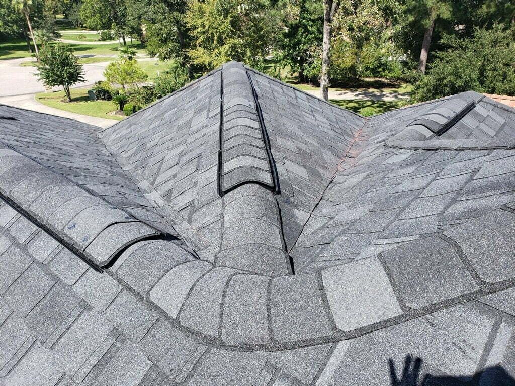 A close up of a roof with a few trees in the background.