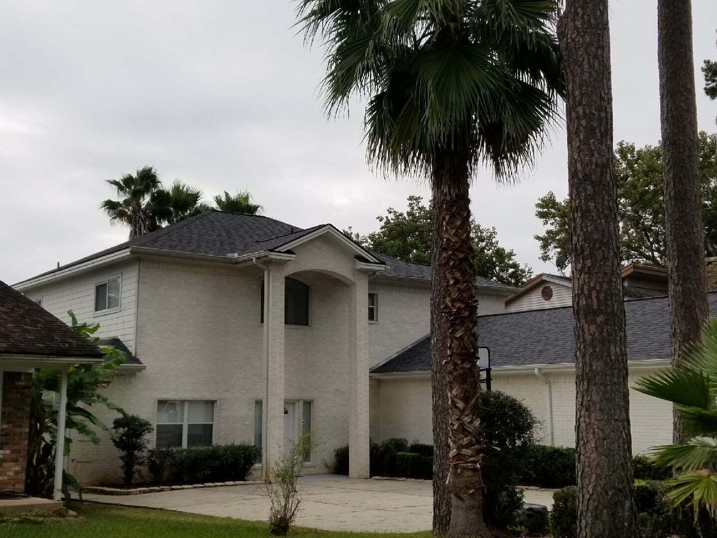A large white house with palm trees in front of it