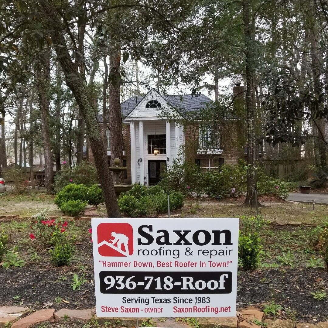 A saxon roofing and repair sign in front of a house
