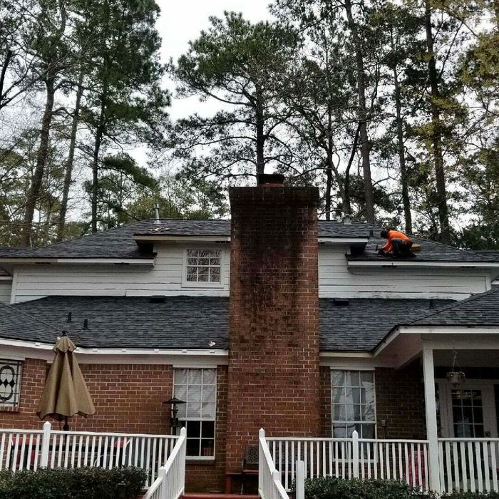 A man is working on the roof of a house.