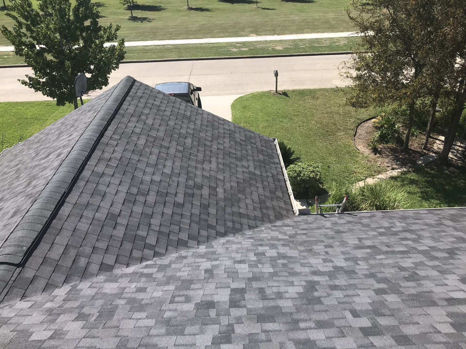 A roof of a house with a car parked on the side of it.