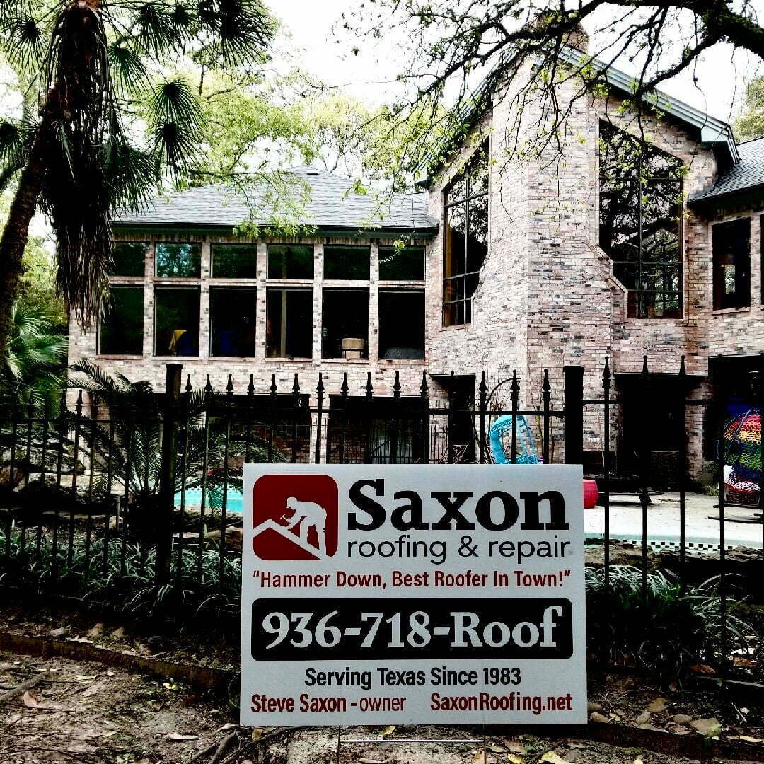 A saxon roofing and repair sign in front of a house