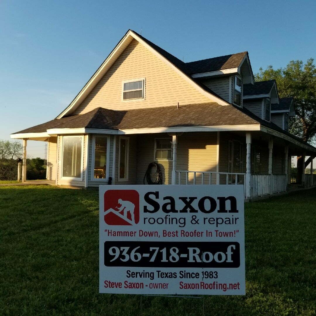 A saxon roofing and repair sign in front of a house