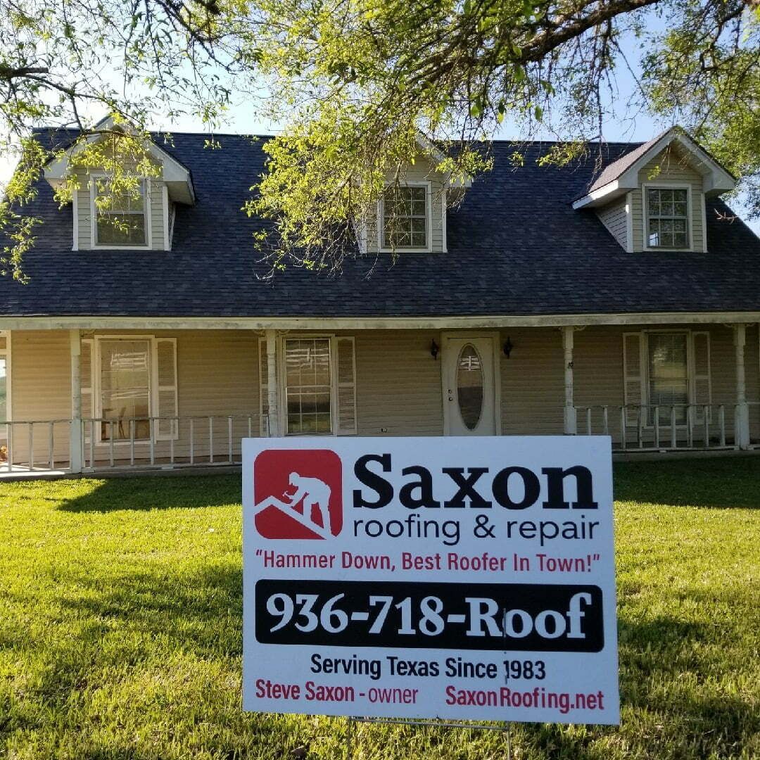 A saxon roofing and repair sign in front of a house