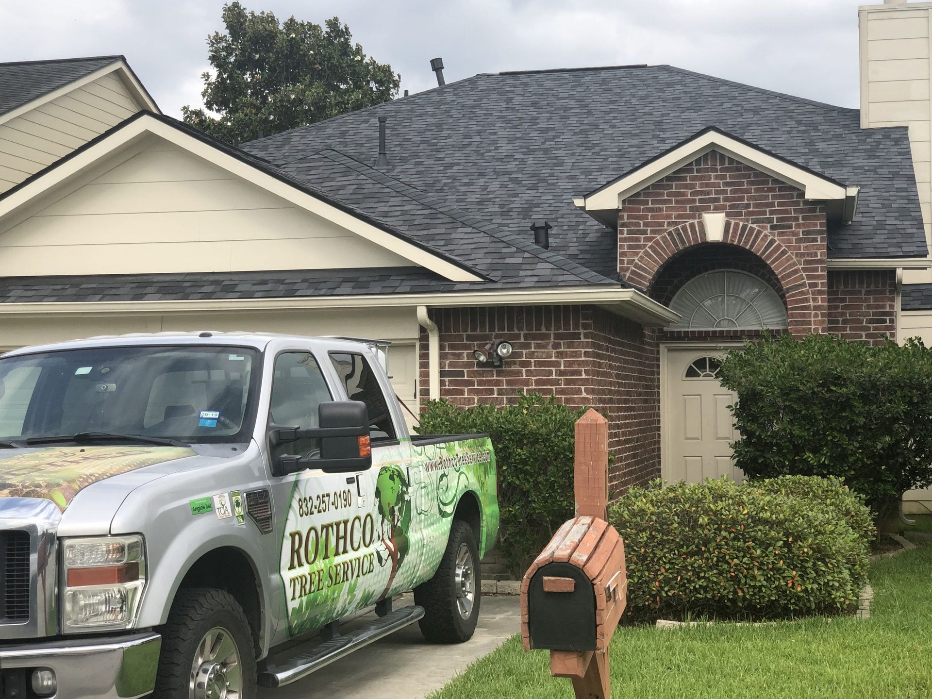 A truck is parked in front of a brick house.