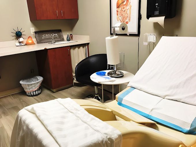 A doctor 's office with a bed and a chair.