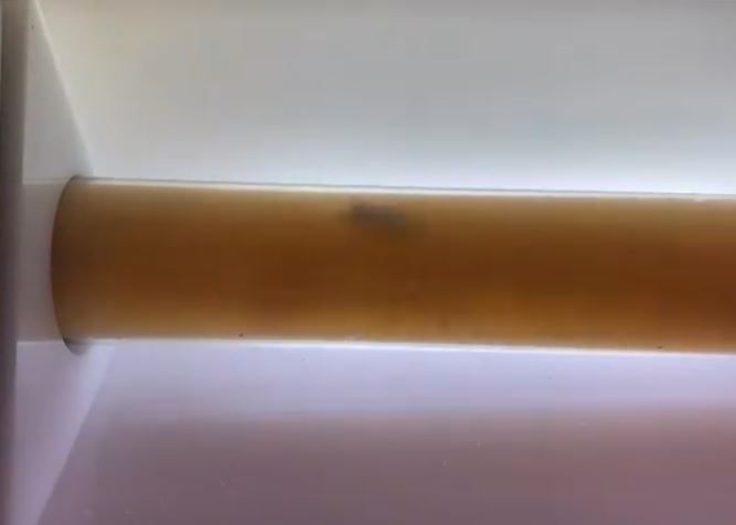 A close up of a wooden railing with a light behind it.