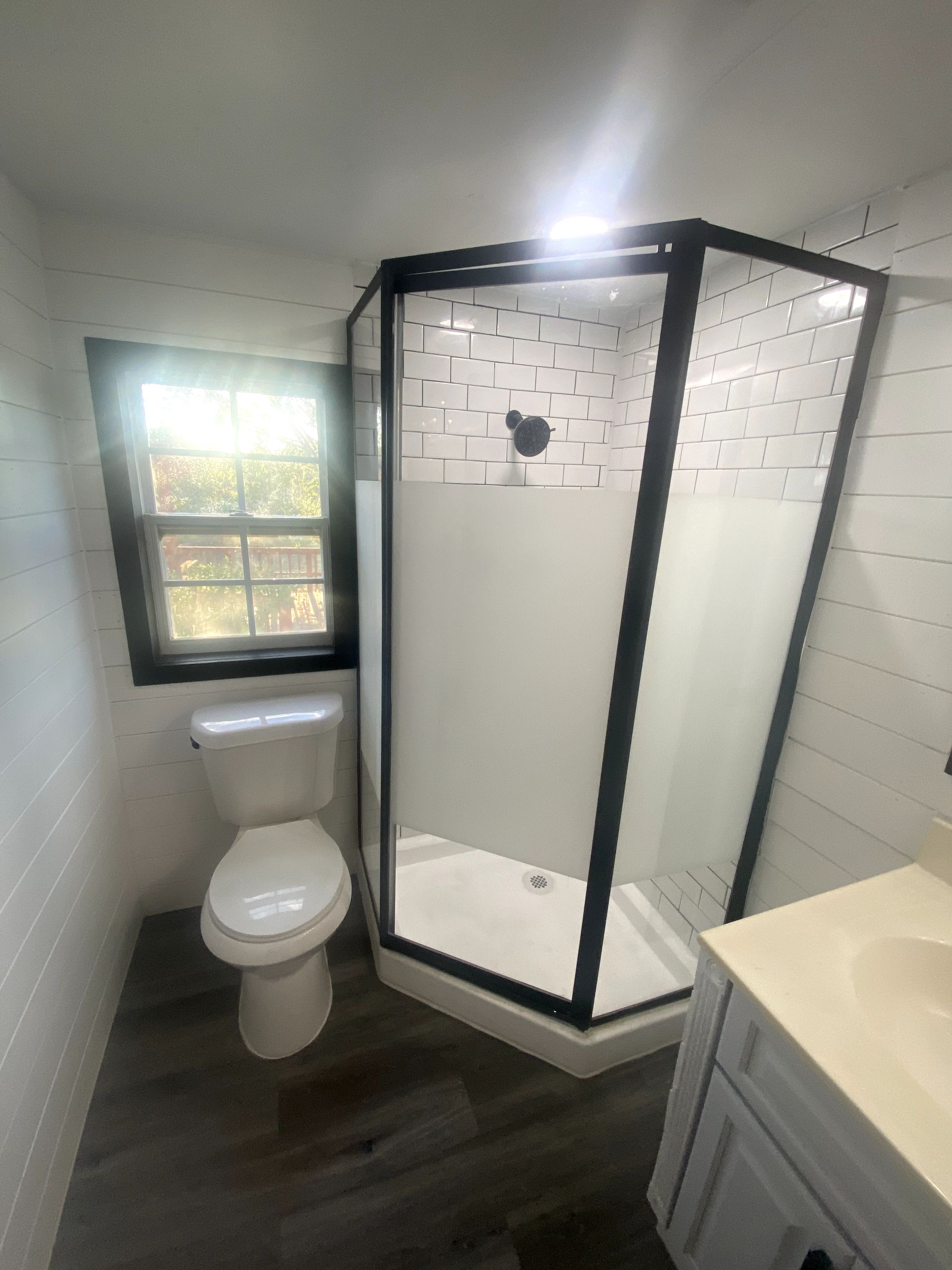 A bathroom with a toilet and a shower stall