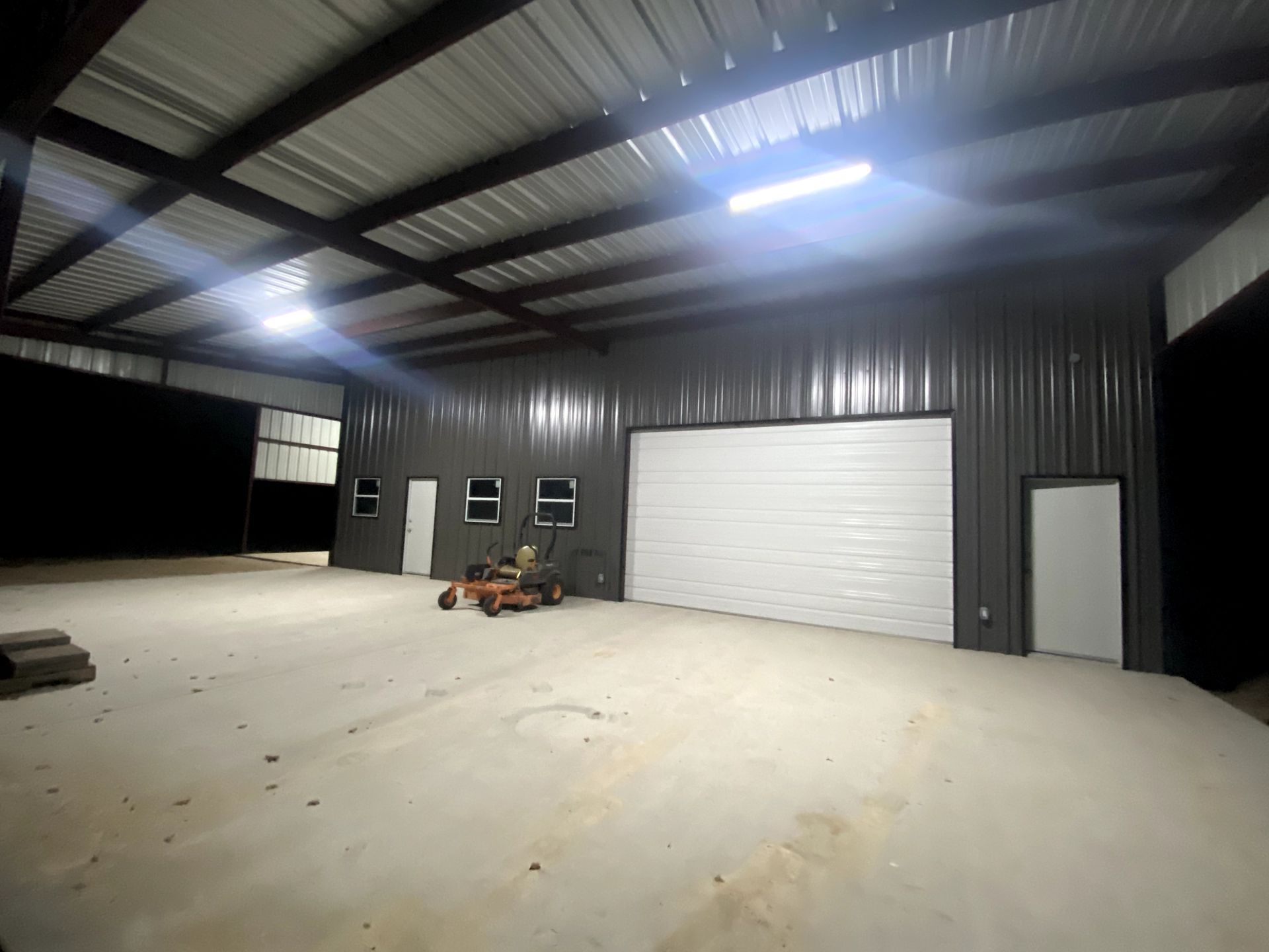 A large empty warehouse with a white garage door.