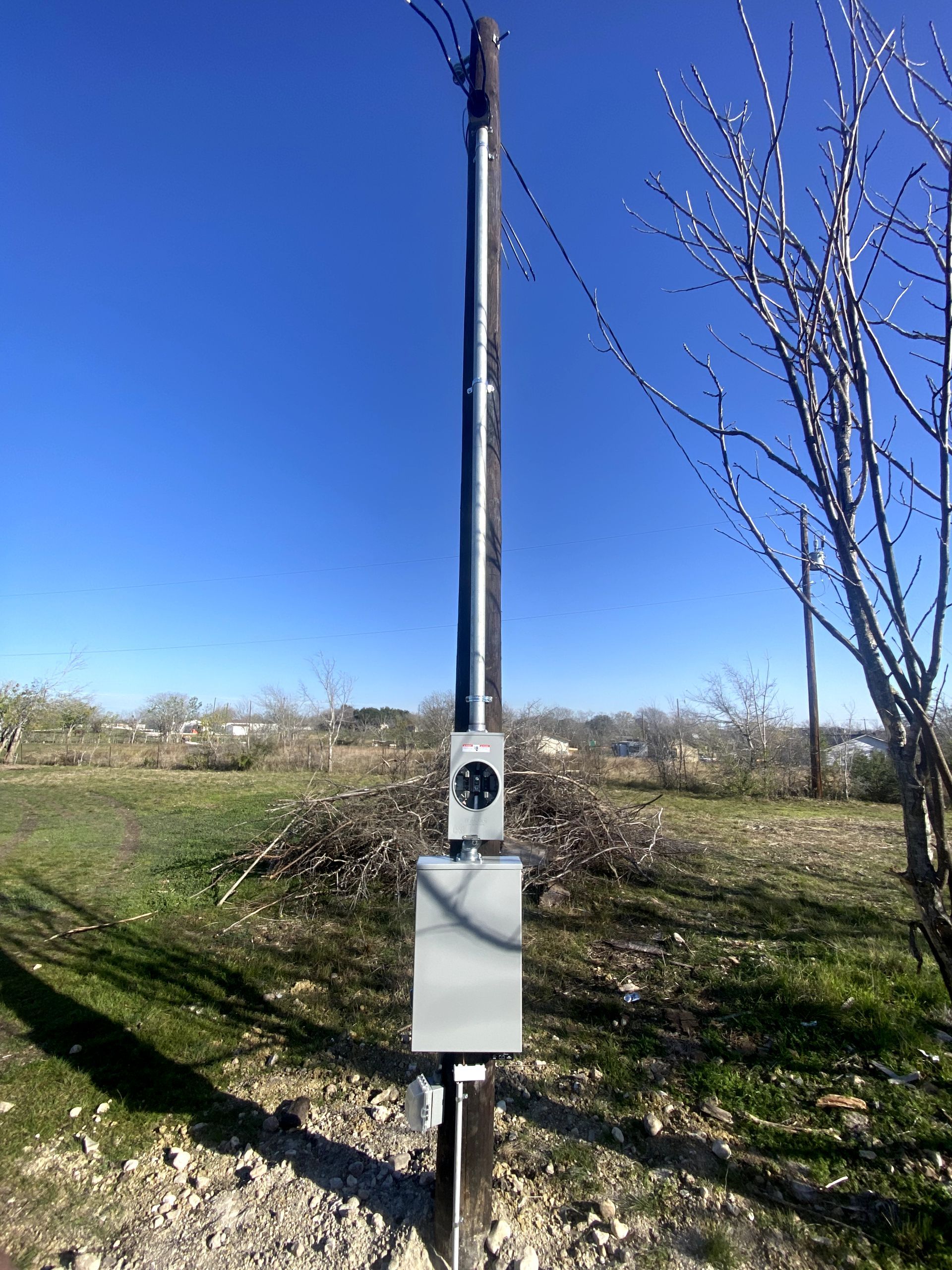 A pole with a box on it is in the middle of a field.