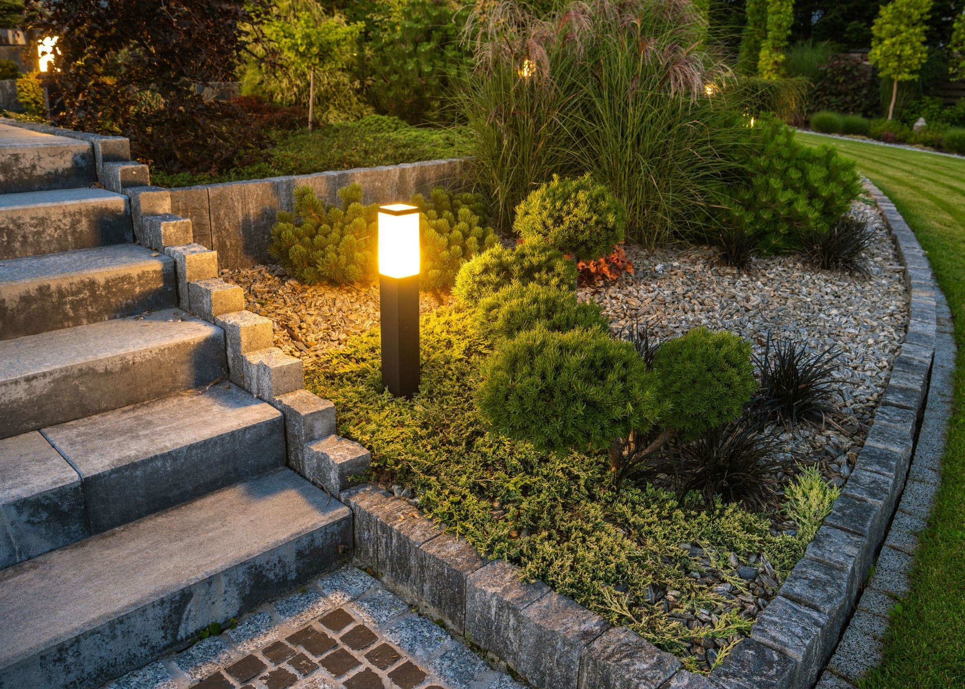 A garden with stairs and a lamp in the middle of it.