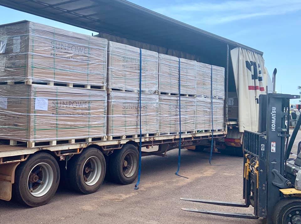 a forklift is loading a truck with boxes on it .