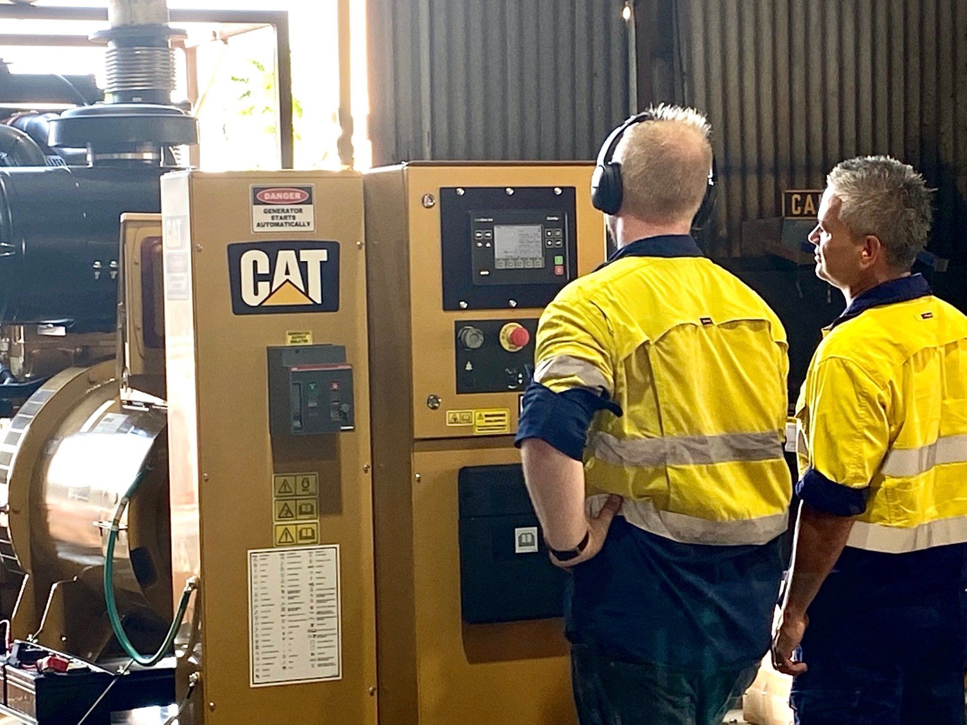 two men are standing in front of a cat machine .