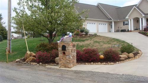 A large house with a stone mailbox in front of it