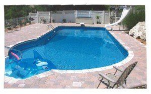 A large swimming pool with a slide in the backyard.
